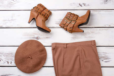 Brown heel boots with three clasps. Top view, womens hat and trousers.の写真素材