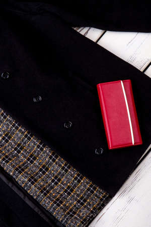Close up red wallet on black coat. Cashmere jacket with red leather purse.