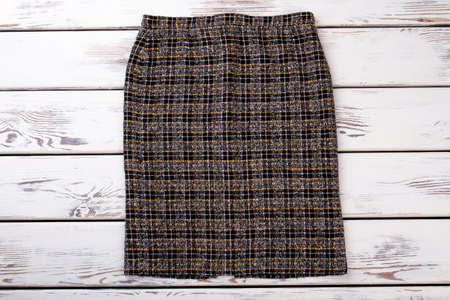 Checkered women shorts. White wooden desks surface background. Top view.の写真素材
