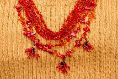 Statement red coral necklace. Yellow wool background.の写真素材