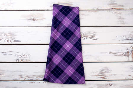Purple checkered skirt. Wooden desks surface background.の写真素材