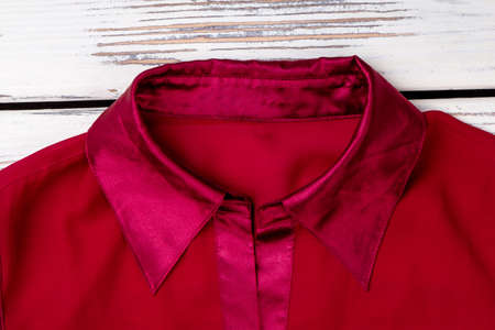Red silk collar, close up. White wooden desks surface background.の写真素材