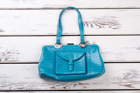 Flat lay blue leather purse. White wooden desks surface background.の写真素材