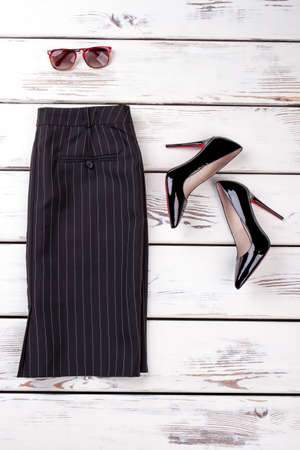 Black striped business skirt. Pair of shiny high heel shoes and spectacles.の写真素材