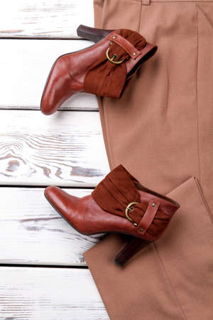 Brown leather shoes on trousers. Flat lay, close up. White wooden background.の写真素材
