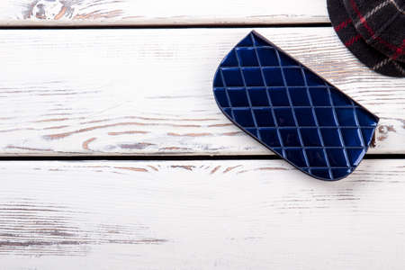 Close up blue shiny wallet. Layout, white wooden background.の写真素材