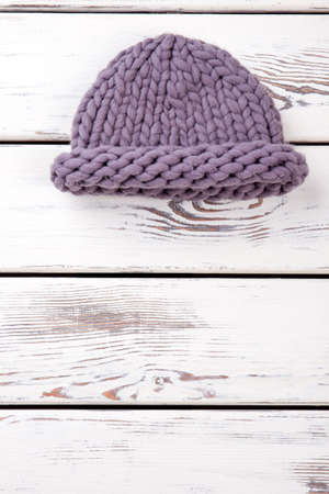 Flat lay purple knitted hat. White wooden desks surface background.の写真素材