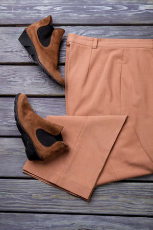 Pair of brown suede shoes and trousers, flat lay. Grey wooden surface background.の写真素材