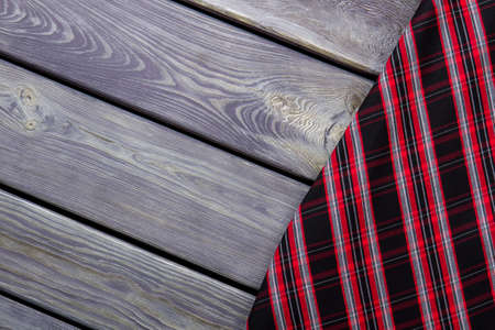 Extreme close up checkered clothes material. Grey wooden surface background.の写真素材