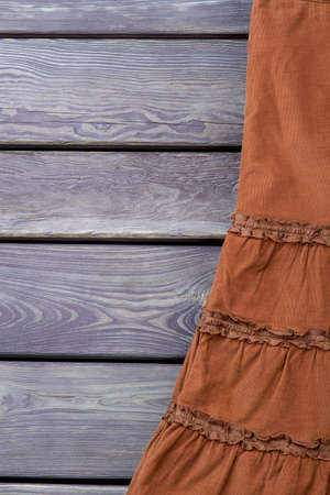 Close up brown clothes material. Wooden desk surface background.の写真素材