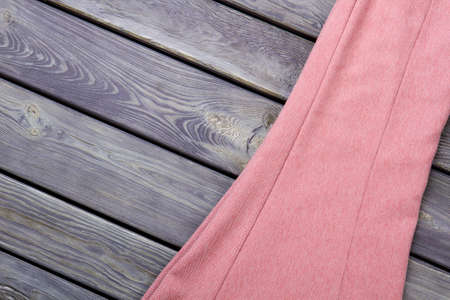 Pink womens dress, flat lay. Wooden desk surface background.の写真素材