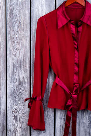 Womens silk clothing. Red coat. Top view, wooden background.の写真素材