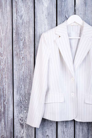White suit jacket on hanger. Dark wooden background. Top view.の写真素材