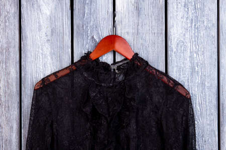 Black lace collar and hanger. Grey wooden desk surface background.の写真素材