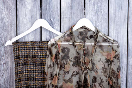 Close up stylish female apparel on hangers. Flat lay, top view. Grey desk surface background.の写真素材