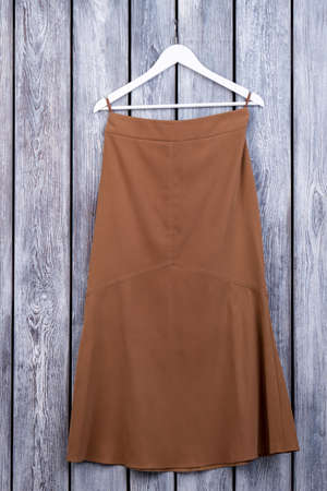Brown dress skirt, flatlay. Top view. Grey desk surface background.の写真素材