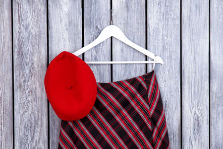 Top view beret hat and checkered skirt on hanger. Desk surface background.の写真素材