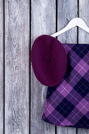 Set of women elegant apparel. Purple violet clothing. Dark wooden desk surface background.の写真素材