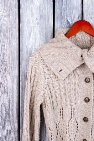 Wool knitted clothes collar on hanger. Flat lay, top view, wooden desk surface background.の写真素材