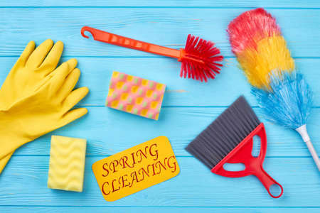 House cleaning products on wood background. Collection of collorful tools for cleaning on blue wooden background, top view. Spring cleaning concept.の写真素材