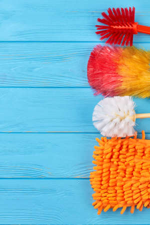 Set of colorful objects for house cleaning. Modern supplies for housekeeping on blue wooden background, copy space. Easy ways to keep house clean.の写真素材