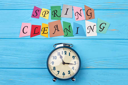 Time for clean up for spring. Blue alarm clock and colorful letters spring cleaning. Time for spring cleaning concept.の写真素材