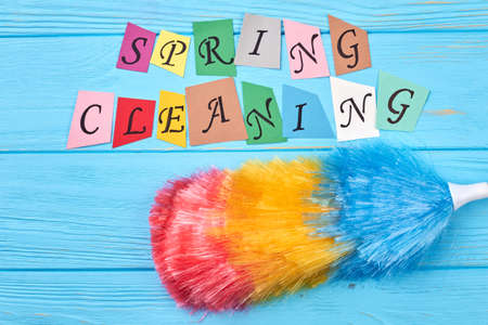 Broom for cleaning on colorful background. Multicolored fluffy duster for cleaning house and...