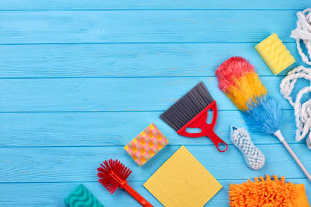 House cleaning products, copy space. Flat lay house cleaning supplies on blue wooden table. Homework and housekeeping concept.の写真素材