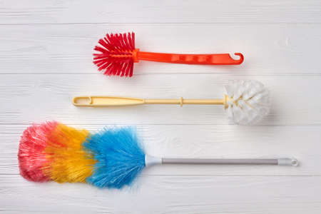 Set of brushes for house cleaning. Three cleaning brushes on white wooden background. Cleaning products on sale.の写真素材