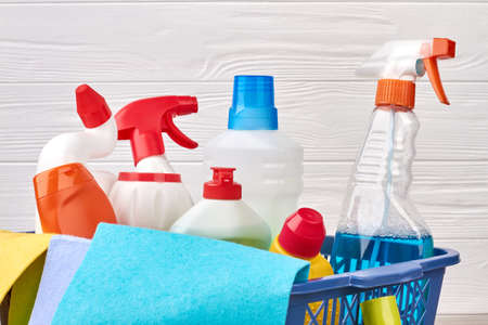 Assortment of detergents in laundry basket. Close up variety of bottles with cleaning liquid. Hacks...