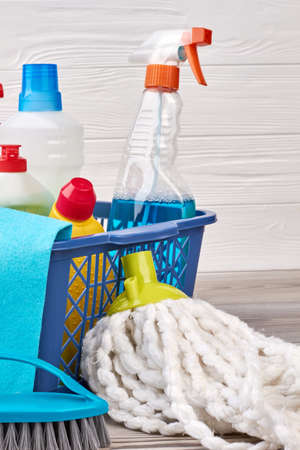 Set of detergents in plastic basket. Mop and brush for cleaning on the floor. Equipment for house work.の写真素材