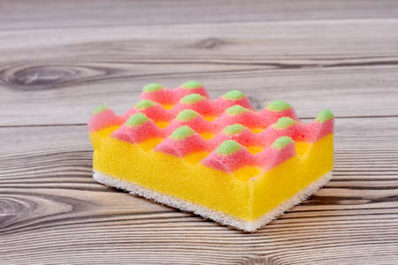 Close up kitchen sponge on wooden background. Sponge for washing dishes close up.の写真素材