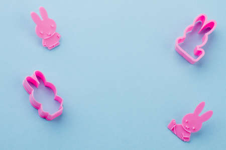 Rabbit shaped pink silicone molds. Silicone molds for cookies baking on blue background and copy space.の写真素材