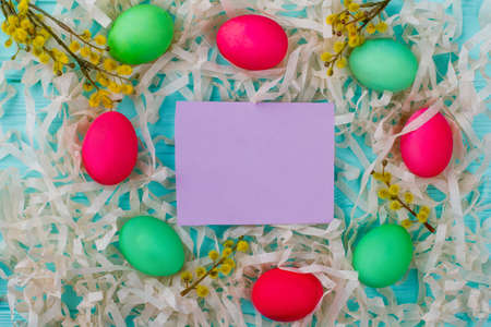 Easter composition and blank paper card. Colorful Easter eggs, pussy-willow twigs with catkins....