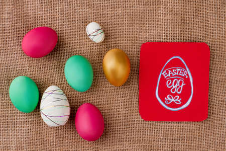 Decorative Easter eggs and paper card. Dyed eggs, styrofoam decorated eggs and golden egg on...