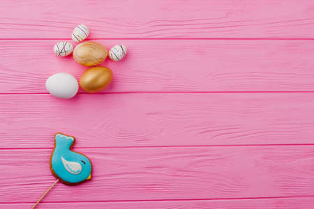 Easter biscuit and decorative eggs. Gingerbread bird shaped cookie