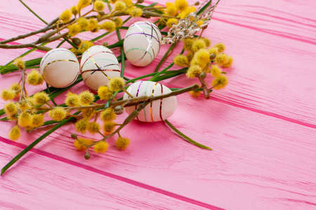 Spring Easter composition with decorative eggs. Modern Easter eggs, pussy willow twigs and grass with copy space. Spring season holiday. Best Easter egg design.の写真素材