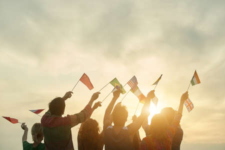 International rally for free borders. People standing and waving international flags. Sunny sky background.の写真素材