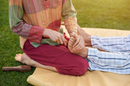 Reflexology foot massage. Spa foot treatment by wood stick.の写真素材