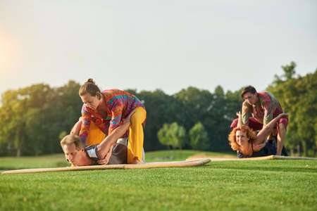 Yoga pose lying on stomach. Group thai massage on the lawn.の写真素材