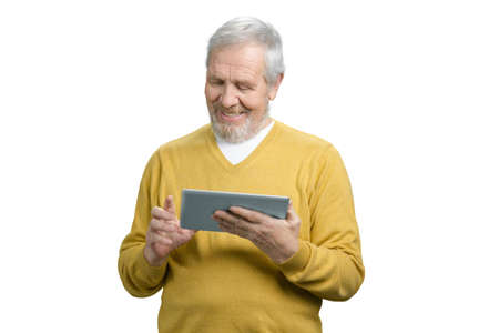 Portrait of smiling cheerful grandpa tapping tablet. Old senior man with modern device gadget. White isolated background.の写真素材