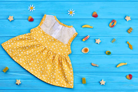 Cotton baby-girl dress, rubber candies. Toddler girls lace floral print dress on blue wooden...