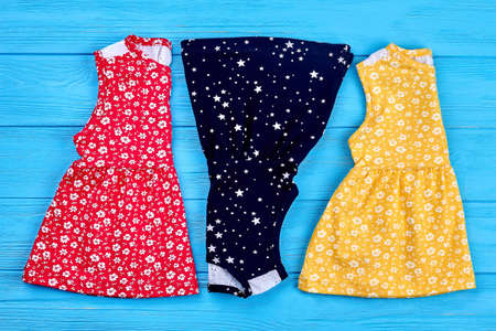 New folded baby summer dresses. Collection of natural toddler girls sundresses on shop shelf. Cute...