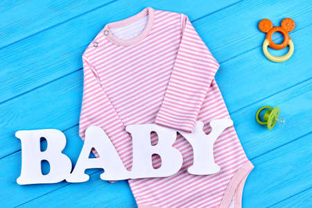 Pink stripes bodysuit for baby-girl. Infant baby natural clothes and accessories background. Brand clothes for infant kids on sale.の写真素材