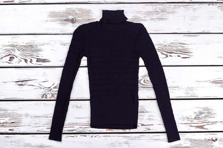 Boys black turtleneck warm sweater. Men winter casual thick warm turtleneck solid color knitted sweater on old wooden background.の写真素材