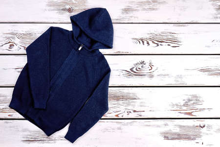 Baby boy knitted hooded sweater. Dark blue hooded jacket for baby boy and copy space, top view.の写真素材