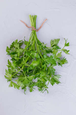 Bunch of fresh parsley, top view. Parsley bunch on gray background. Aromatic herbs for dishes and...