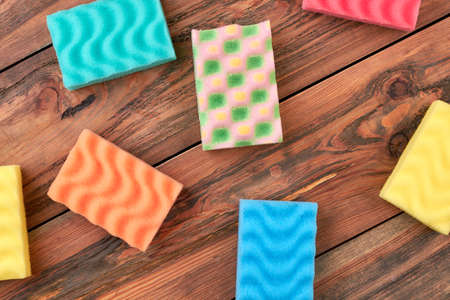 Group of multicolored kitchen sponges. Set of colorful sponges for kitchen on wooden background....