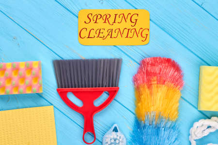 Group of colorful objects for house cleaning. Set of spring cleaning supplies on blue wooden background. Make your home cleaner with cleaning service.の写真素材