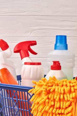 Set of cleaning supplies on wooden background. Bottles with cleaning liquid and microfiber gloves close up. Time for clean up.の写真素材